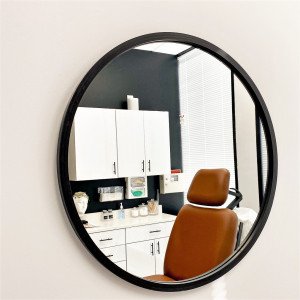 circular mirror on wall with reflection of exam room