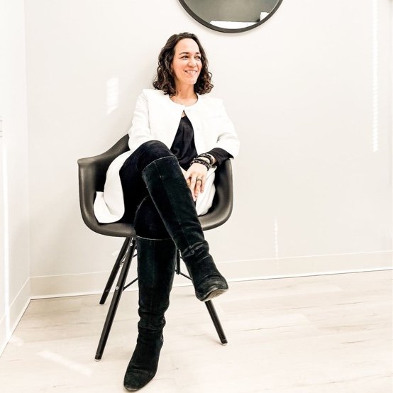 Dr. Kally Papantoniou sitting on a chair