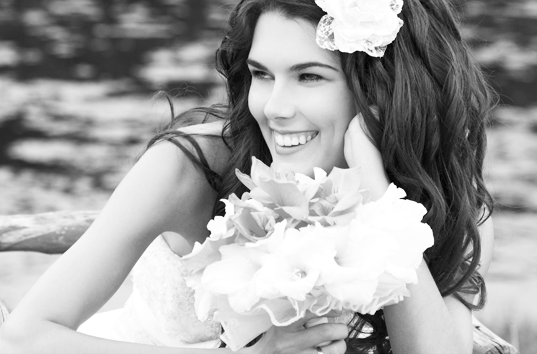 Bride Smiling while lying down holding flowers