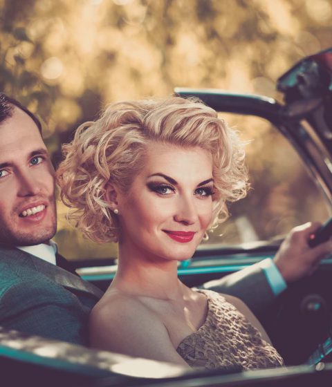 couple in car looking back and smiling