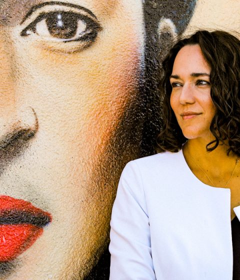 Dr Kally Papantoniou in front of graffiti wall